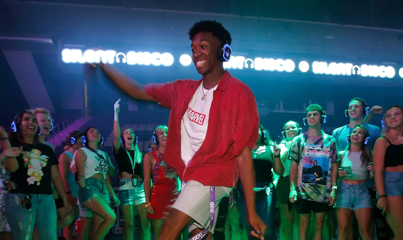 Students enjoying a silent disco campus event with wireless LED headphones while dancing together at a university party hosted by Party Headphones.